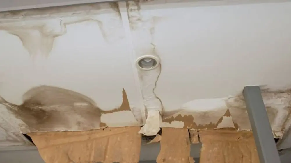 Water-stained ceiling with a section of damaged drywall