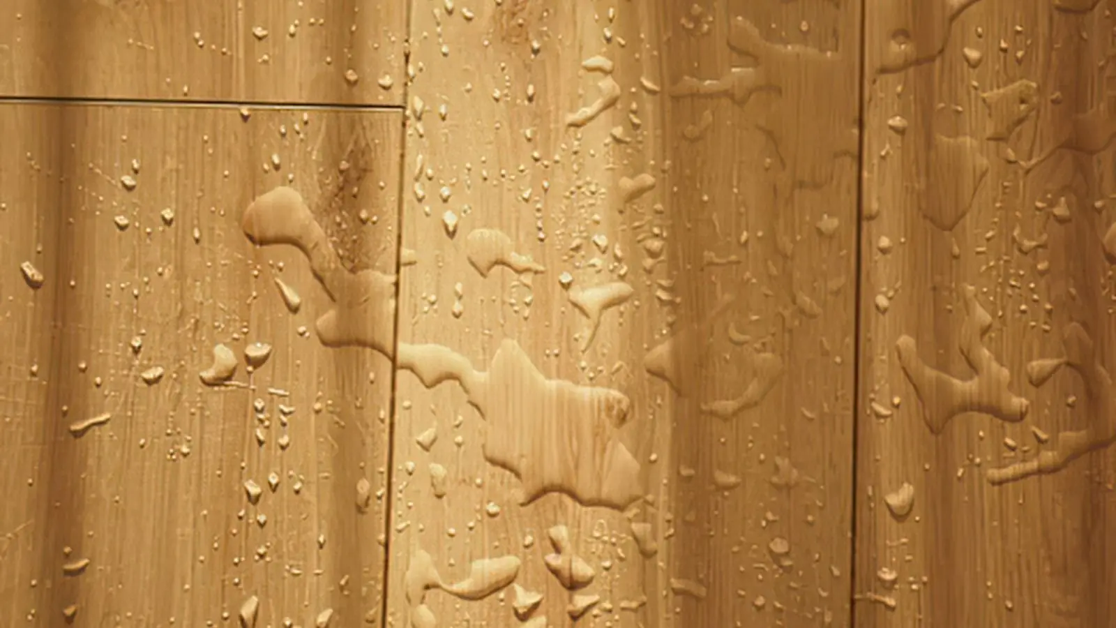 Water beads and wet streaks on a wood plank floor